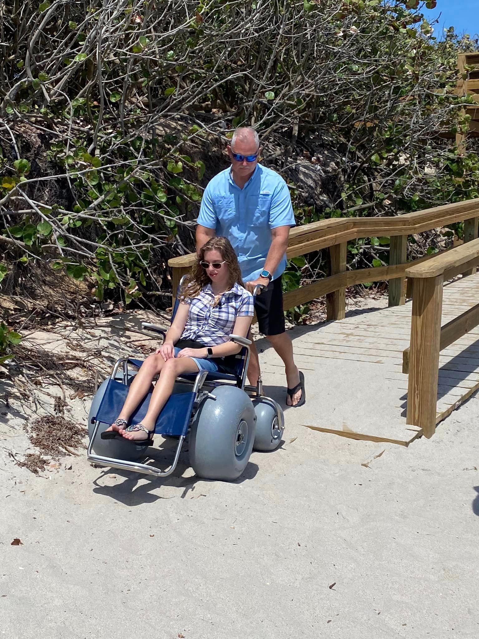 a girl being pushed in a wheelchair on the peer