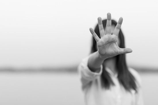 donna vittima di abuso con la mano aperta