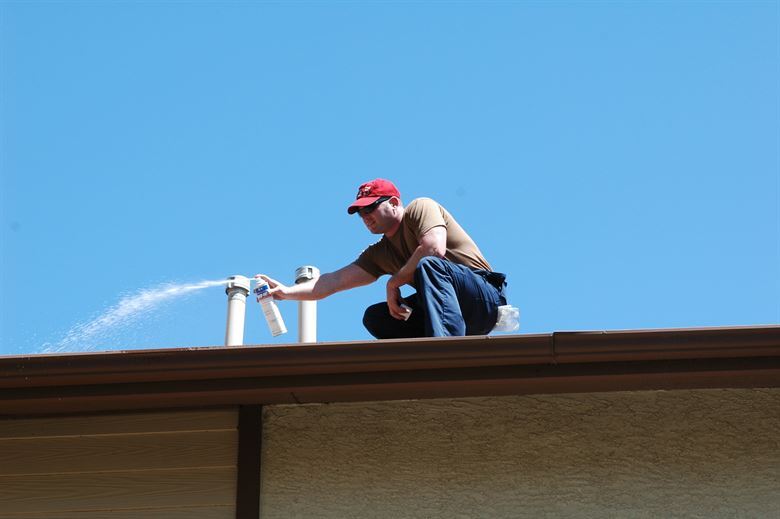 Man Cleaning House Roof — Muncie, IN — American Pest Control