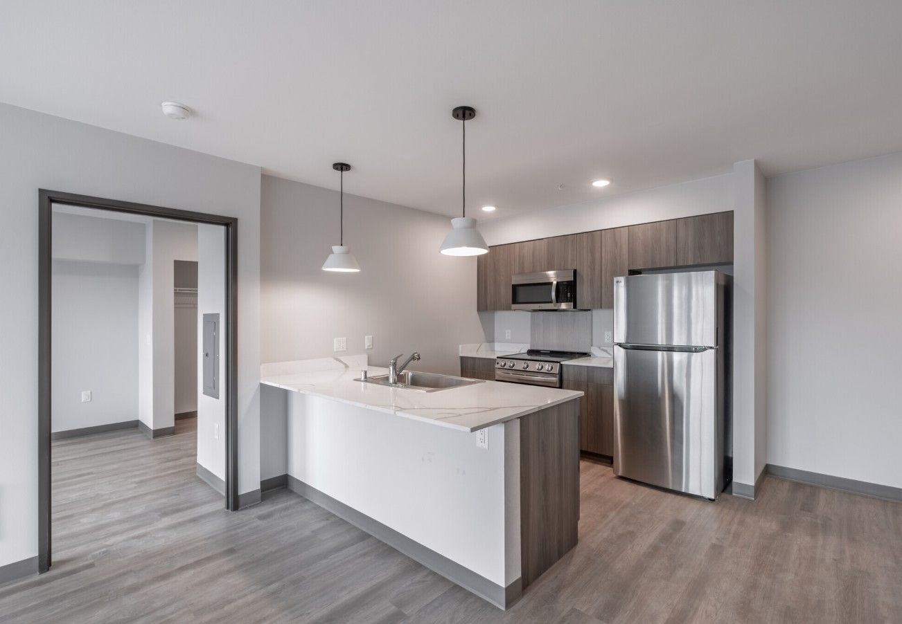 A kitchen with a stainless steel refrigerator , stove , microwave and sink.