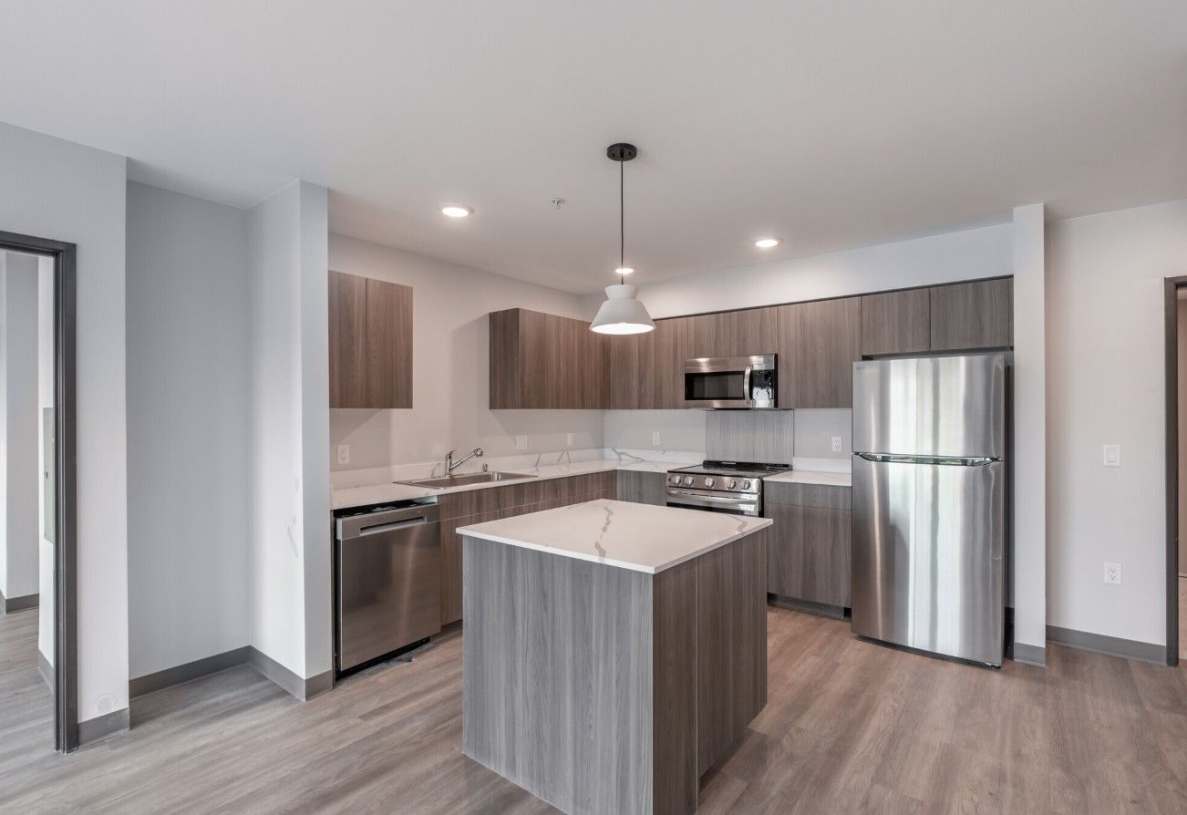 A kitchen with stainless steel appliances and wooden cabinets.