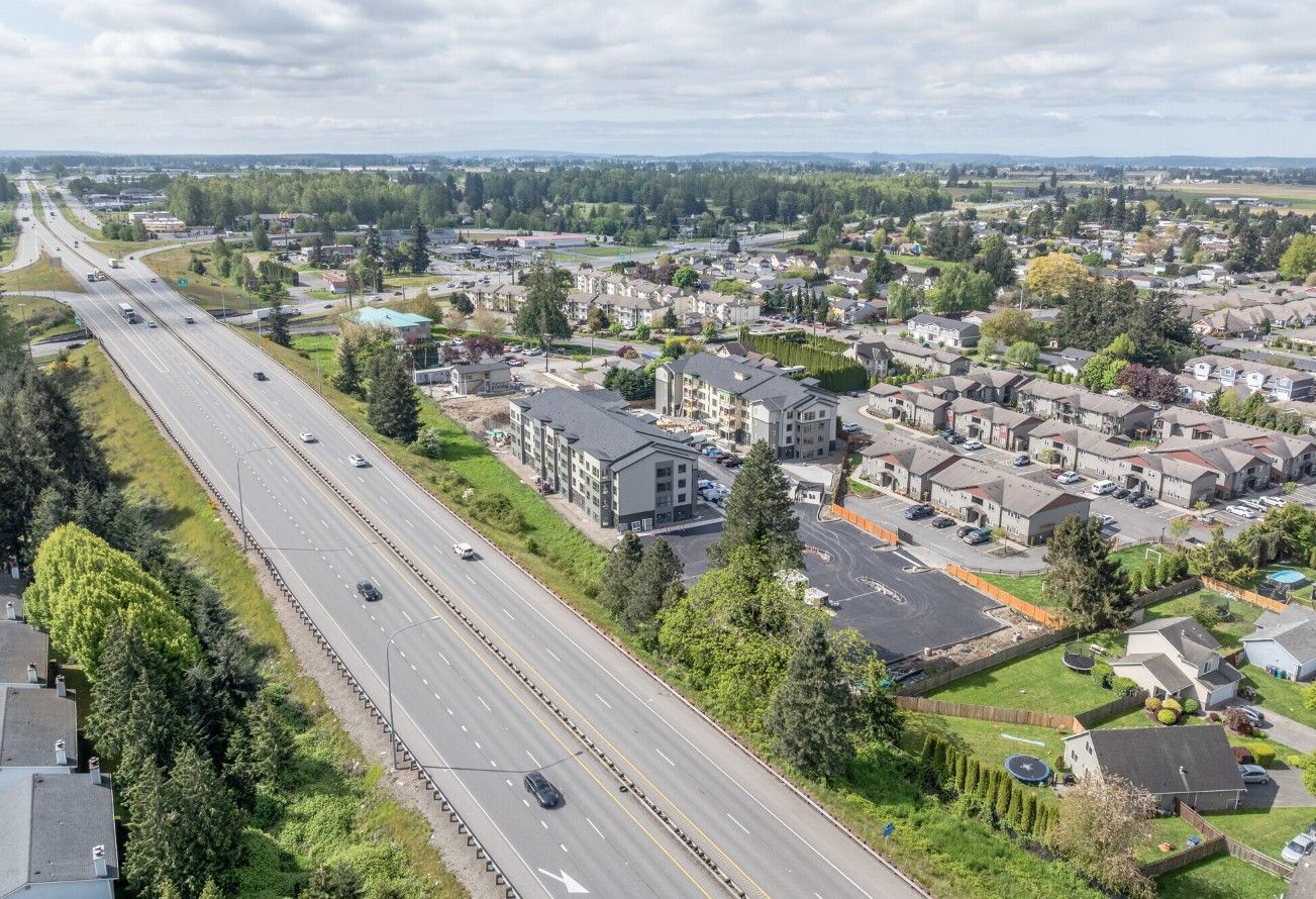 An aerial view of a highway going through a residential area.