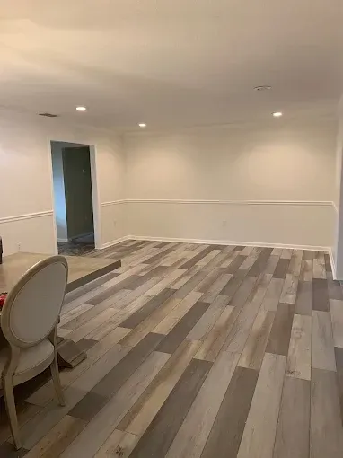 A living room with a wooden floor and white walls.
