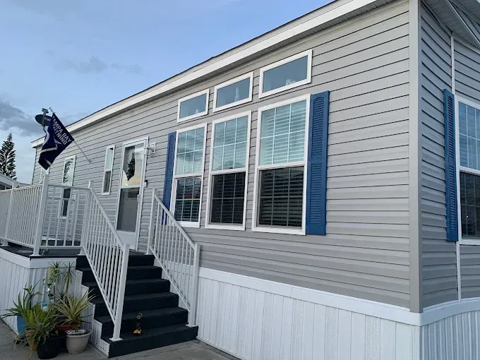A mobile home with stairs leading up to the front door.