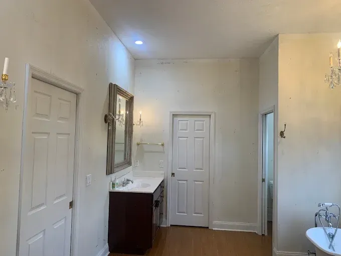 A bathroom with a sink , mirror and tub.