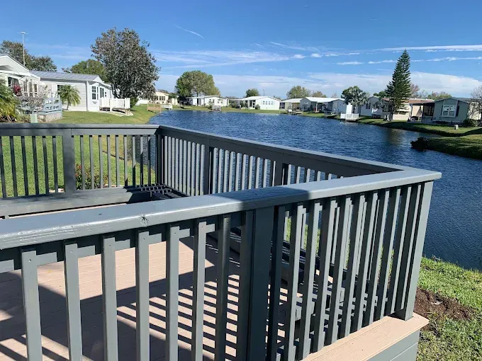 A deck overlooking a body of water with houses in the background