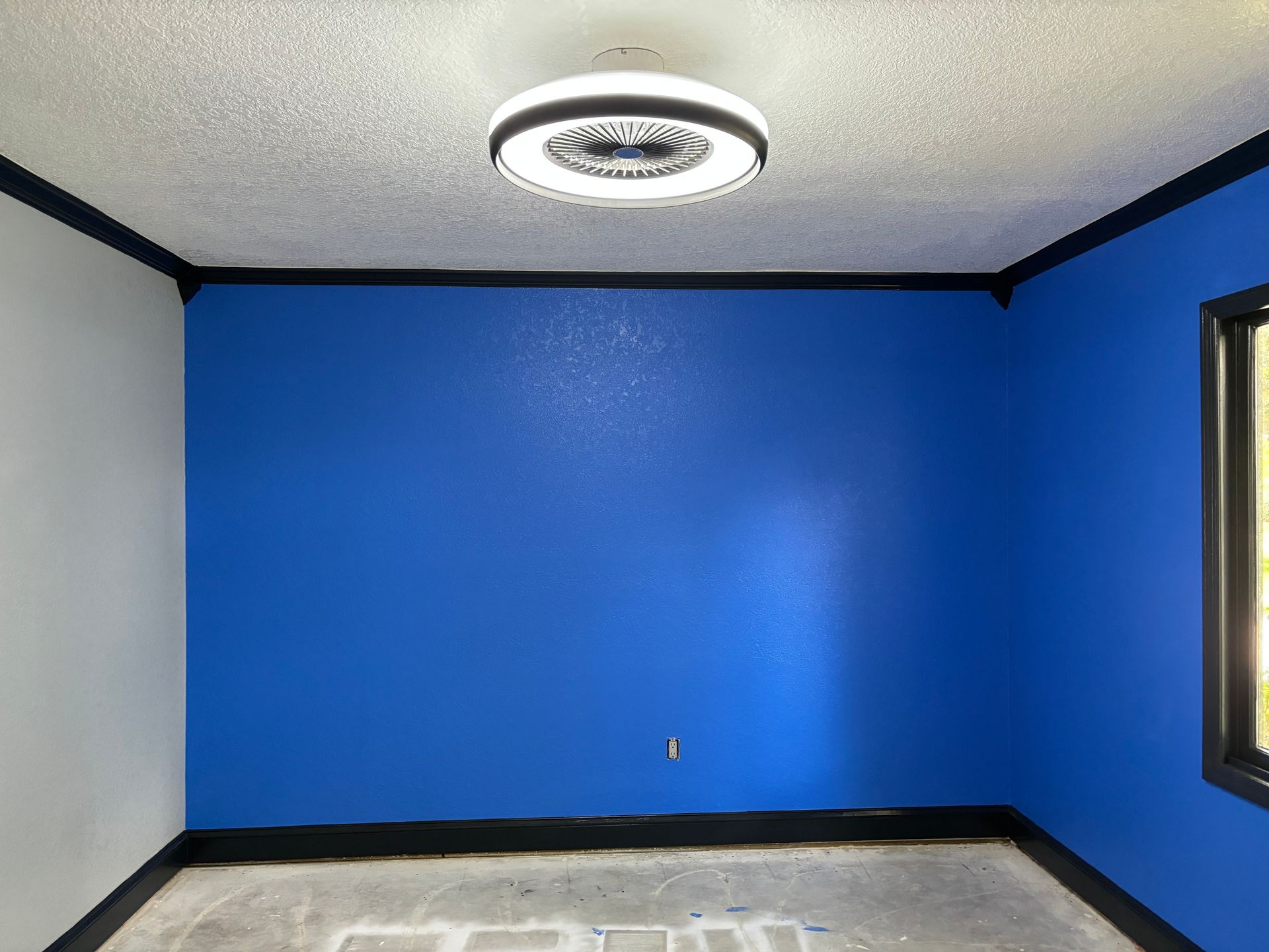 Room with blue and gray walls, black trim, and a circular ceiling light.