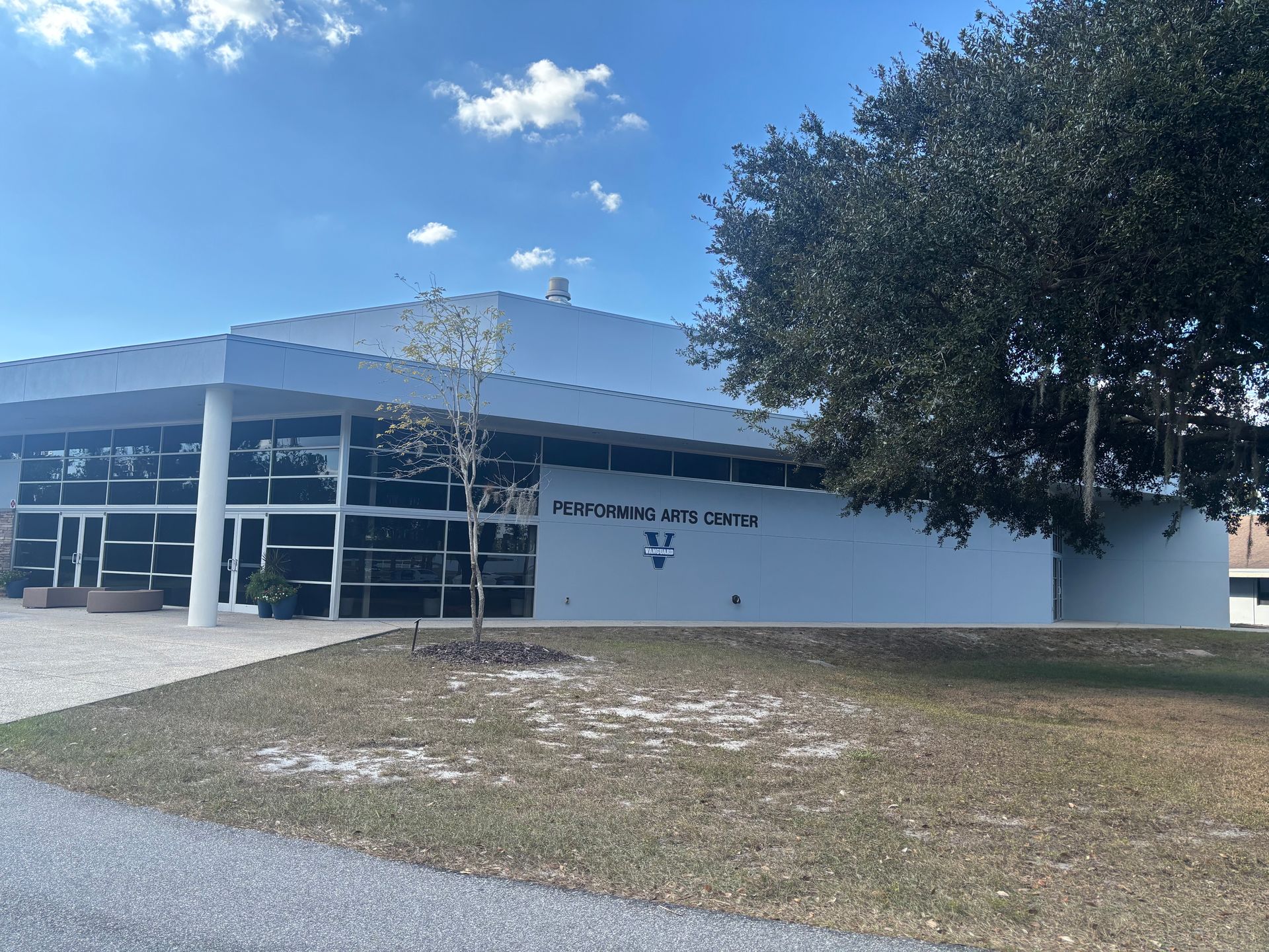 Exterior view of the Winter Haven Arts Center building with a blue sky and trees.