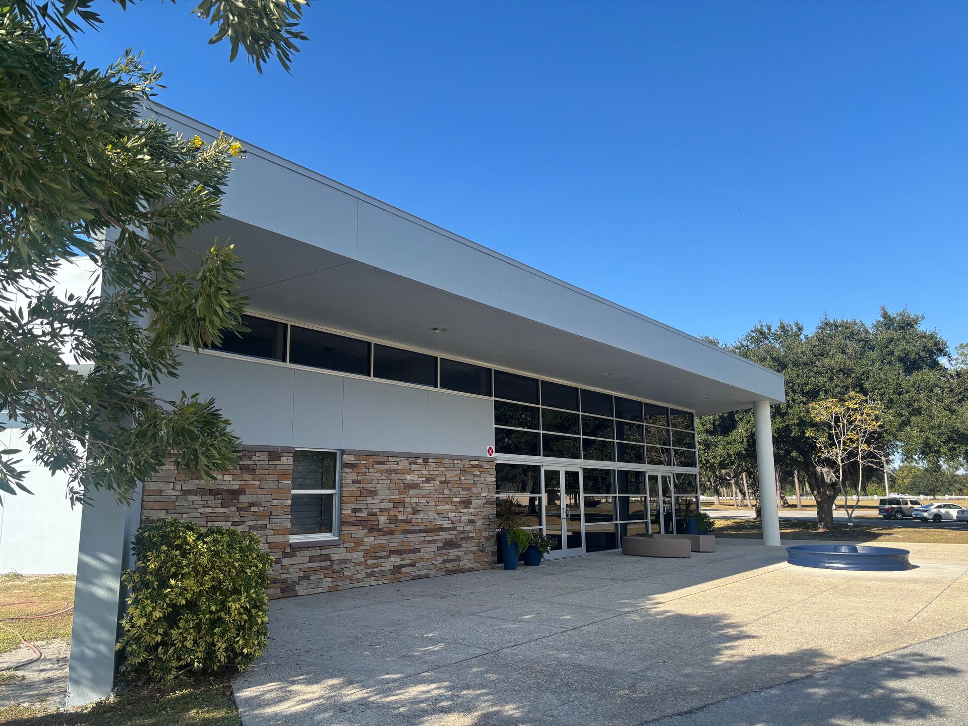 Modern building with stone and glass facade; sunny day.