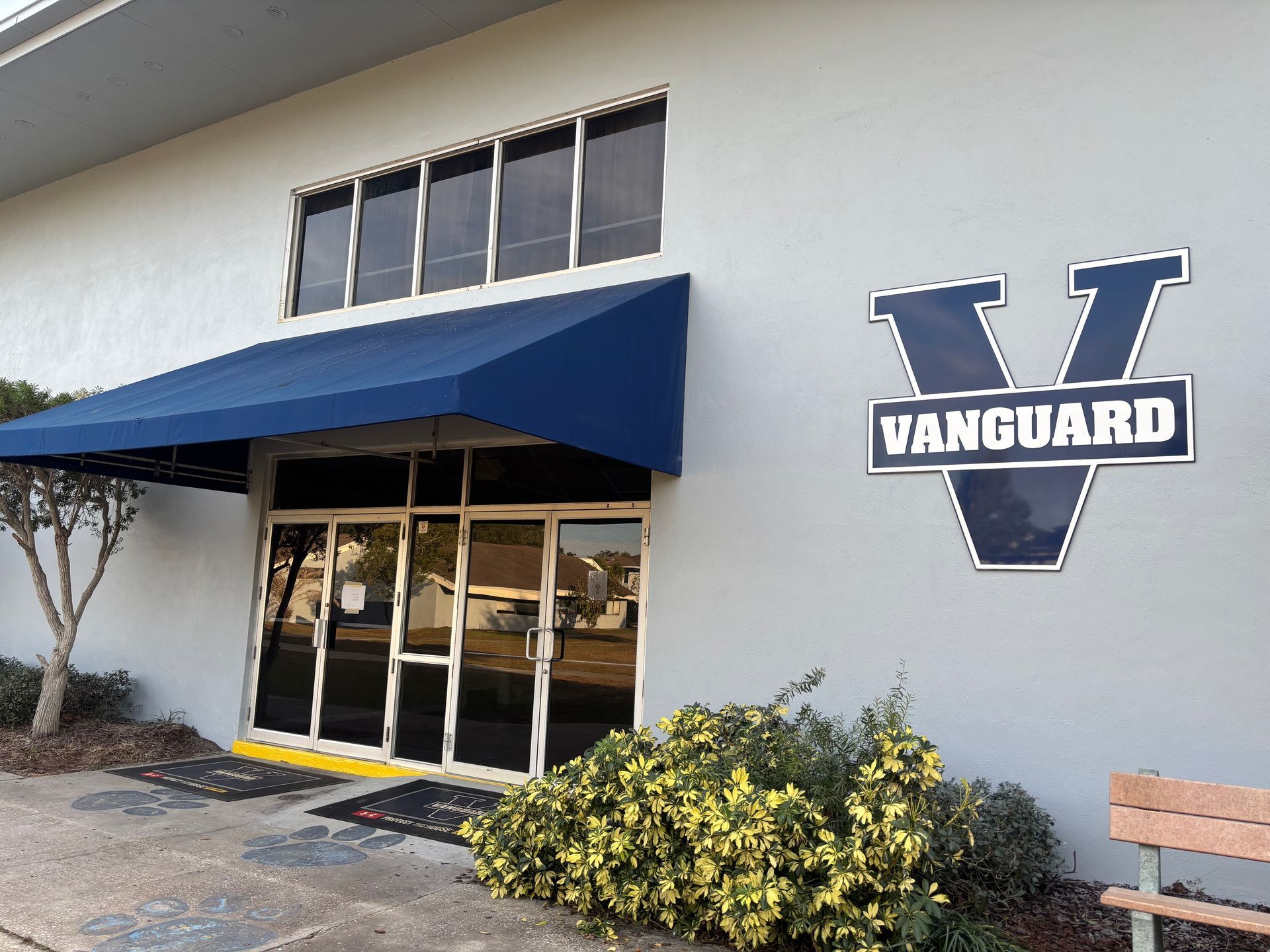 Gray building with blue awning and 