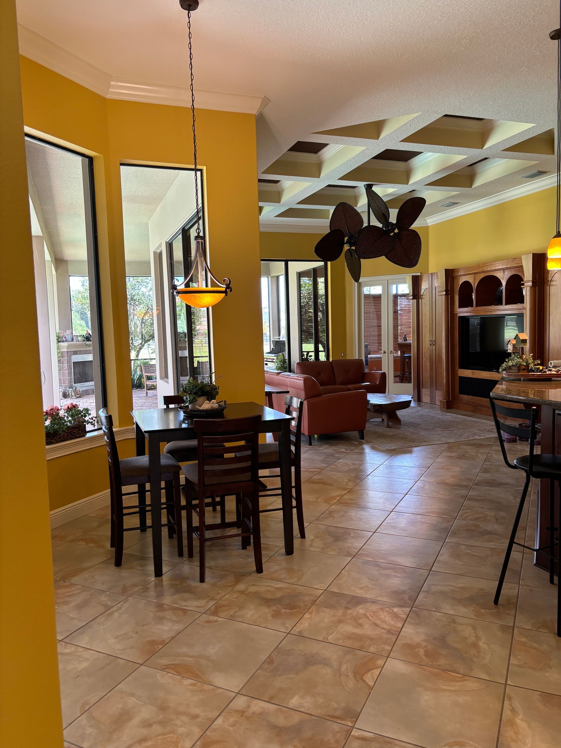 Dining room with table, chairs, and pendant light, with a view into a living area.