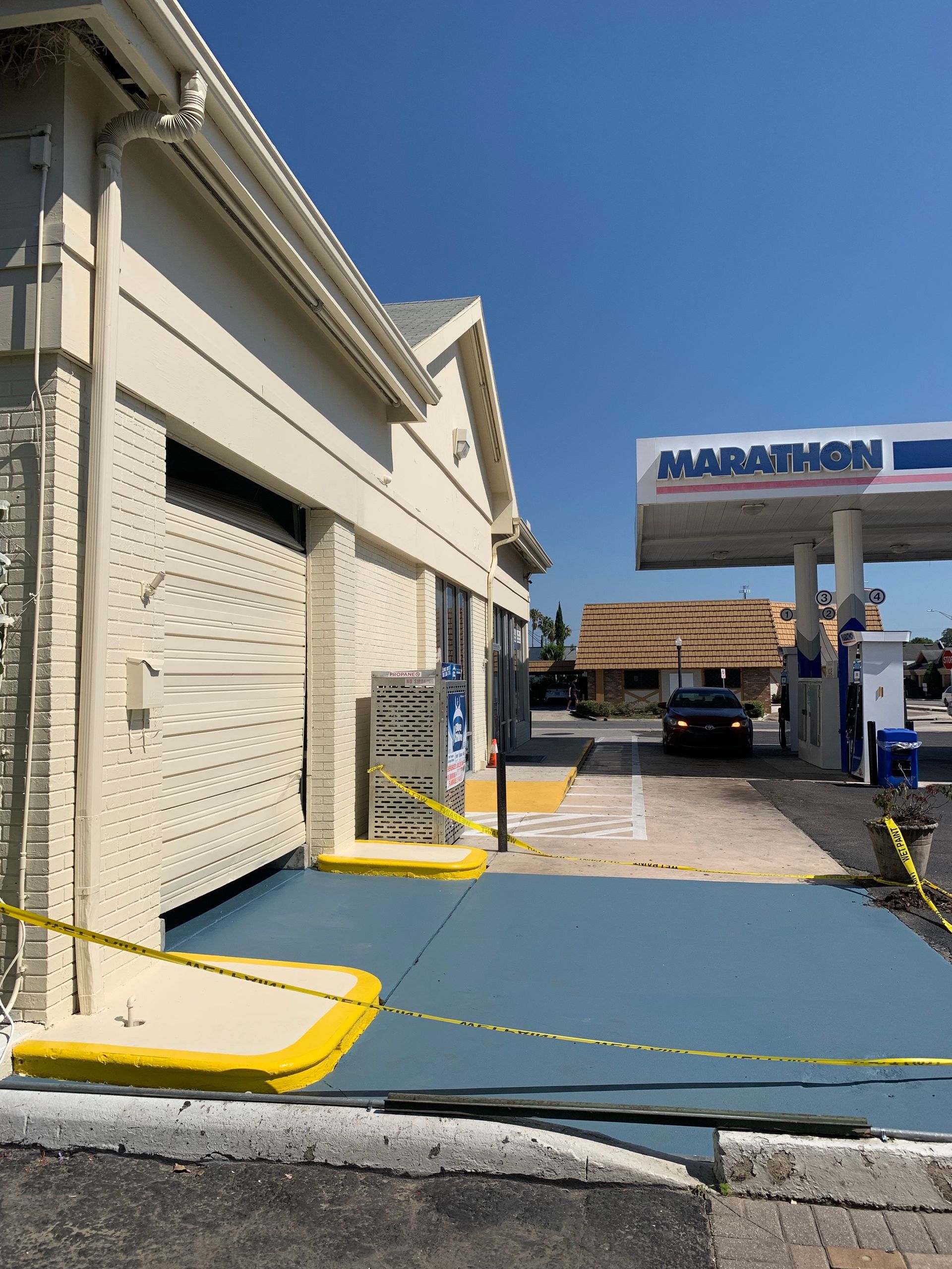Gas station with ramp and blue painted surface, Marathon sign in the background.