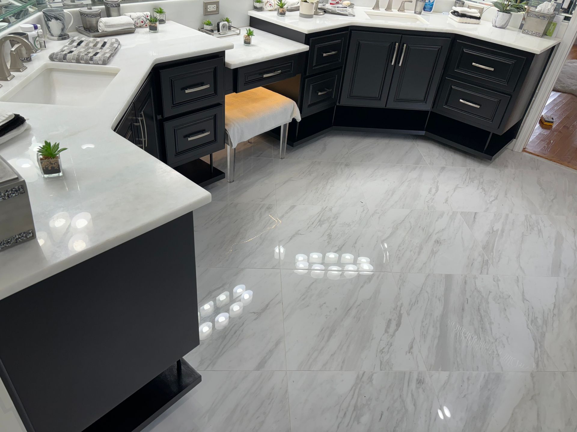 A bathroom with black cabinets and white counter tops