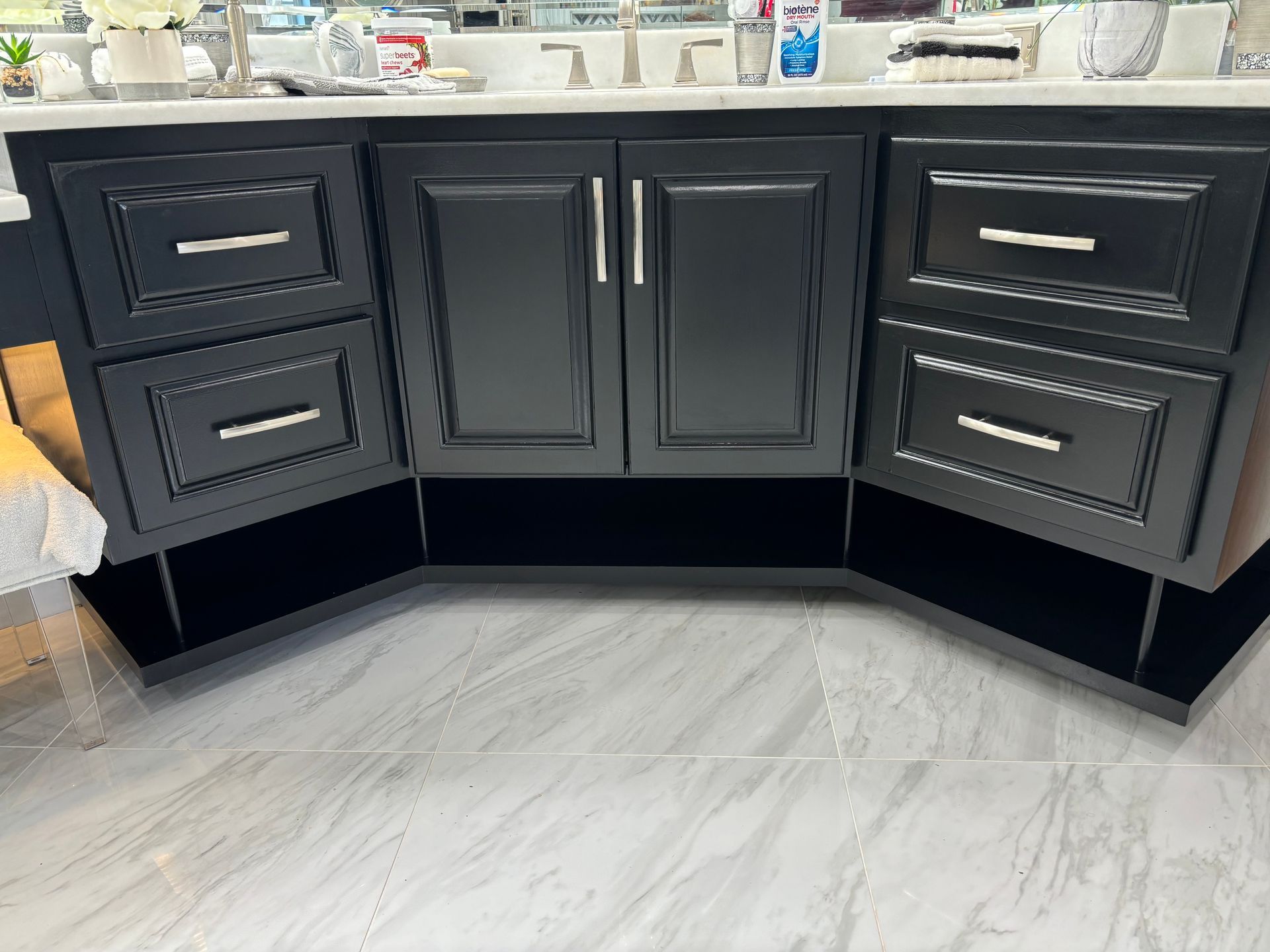 A bathroom vanity with black cabinets and drawers and a sink.