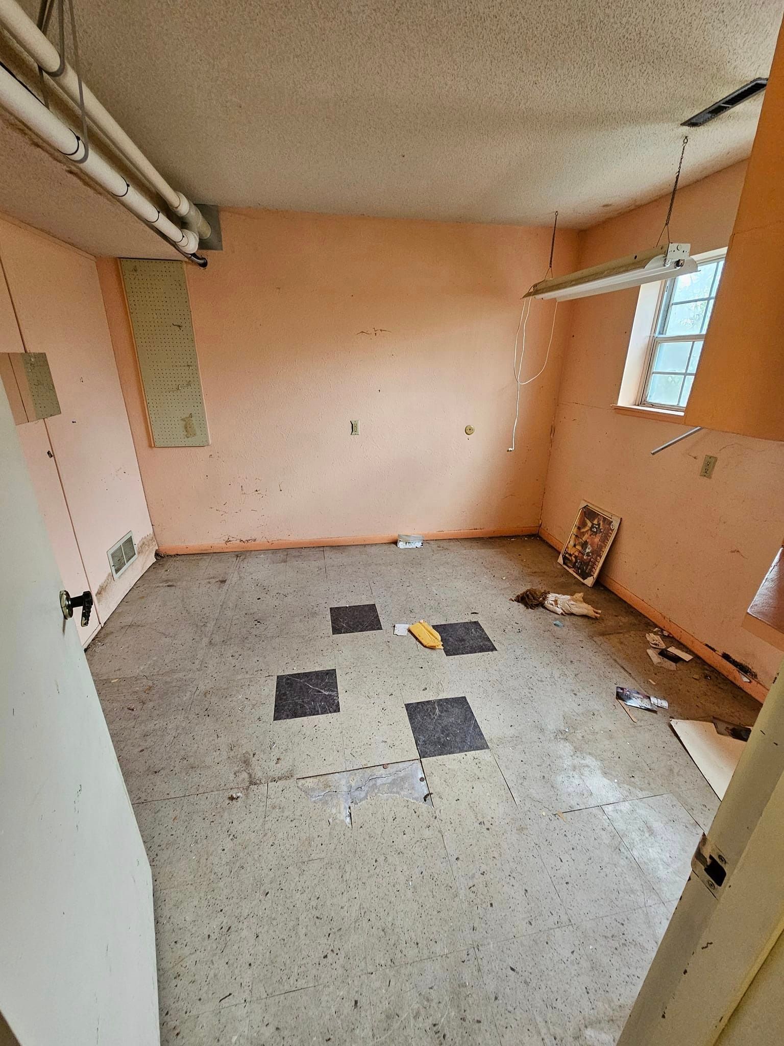 An empty room with a tiled floor and a window.