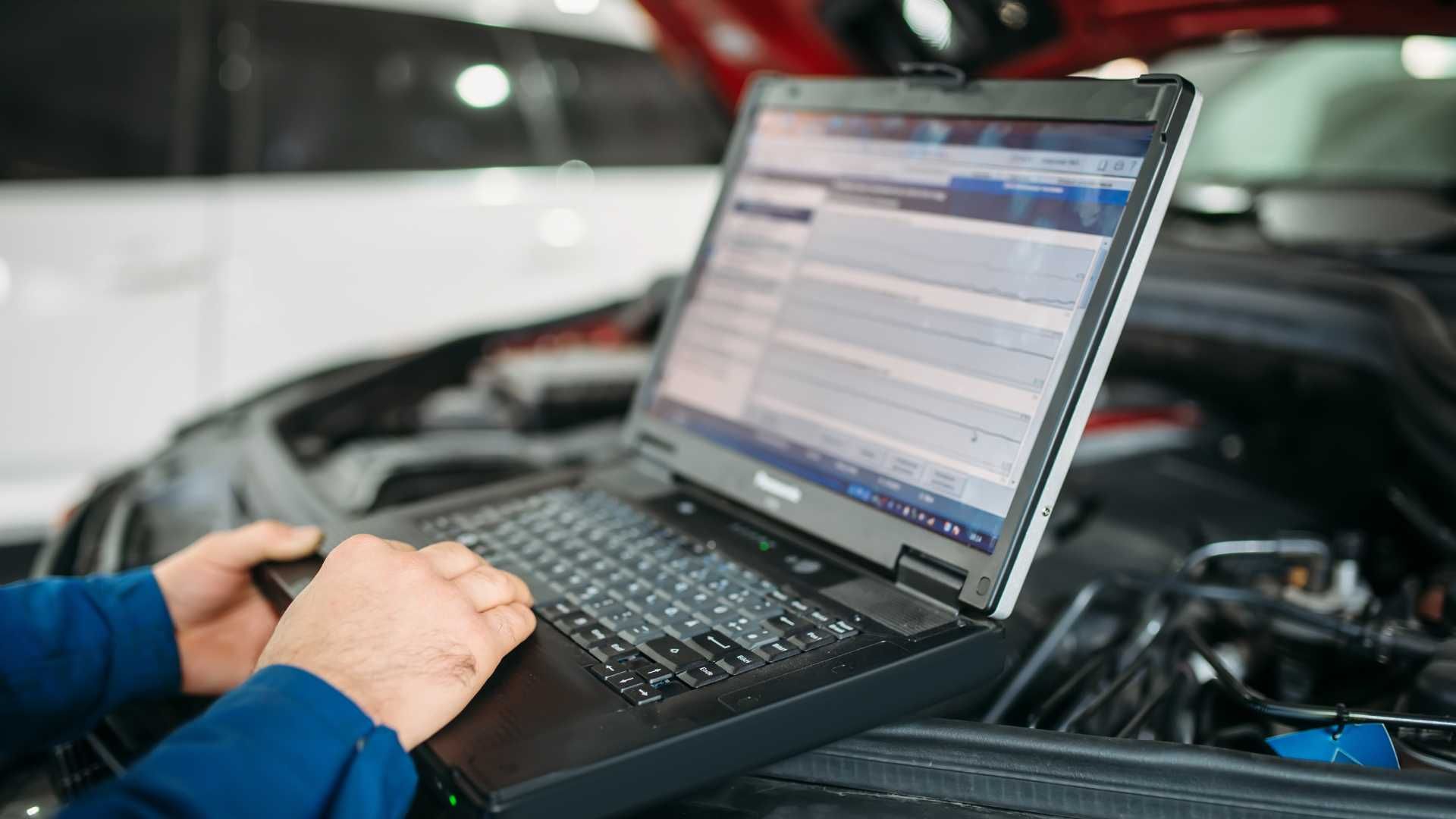 mechanic running car diagnostics on his laptop