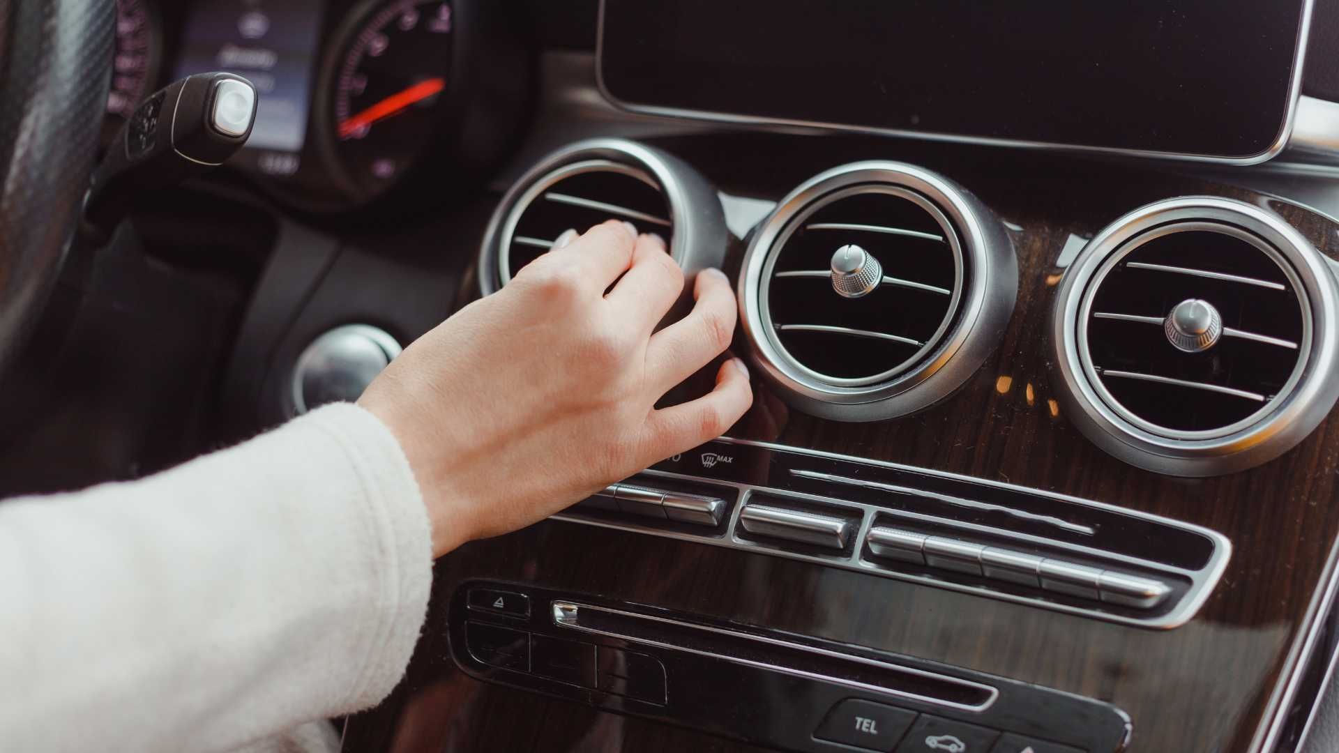 a woman's hand adjusting the interior heat vent direction