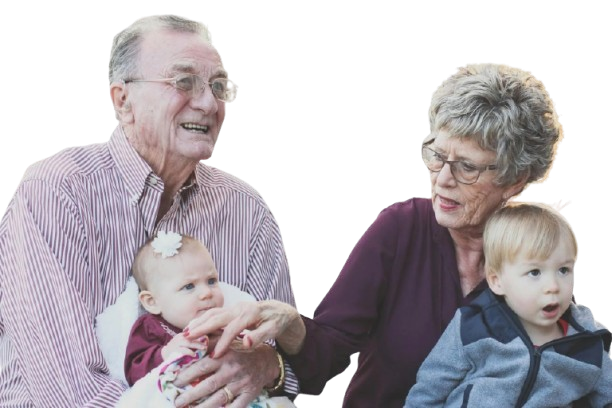 An elderly couple is sitting on a couch looking at a piece of paper.