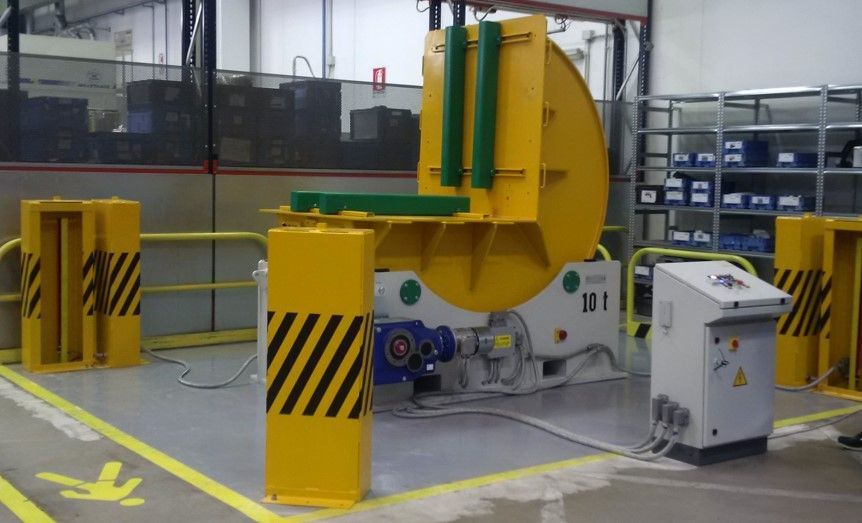 Macchina industriale gialla in configurazione di fabbrica, con barriere di sicurezza e pannello di controllo.