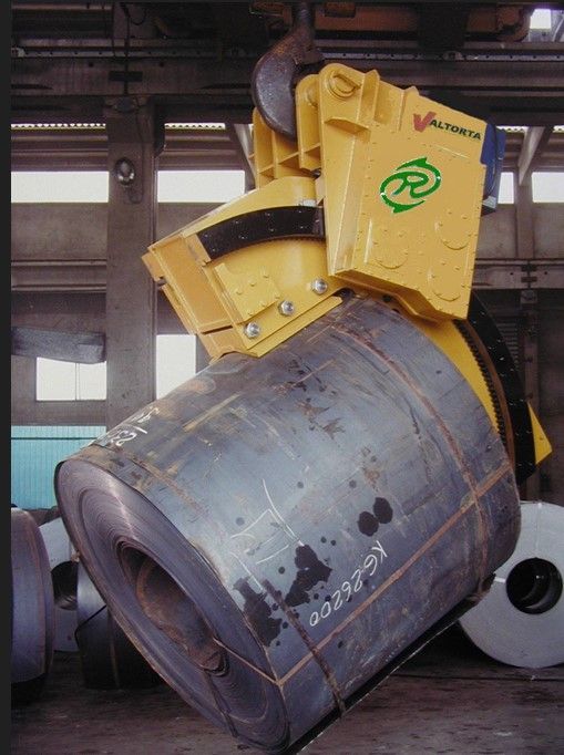 Gru gialla che solleva una grande bobina d'acciaio in una fabbrica.