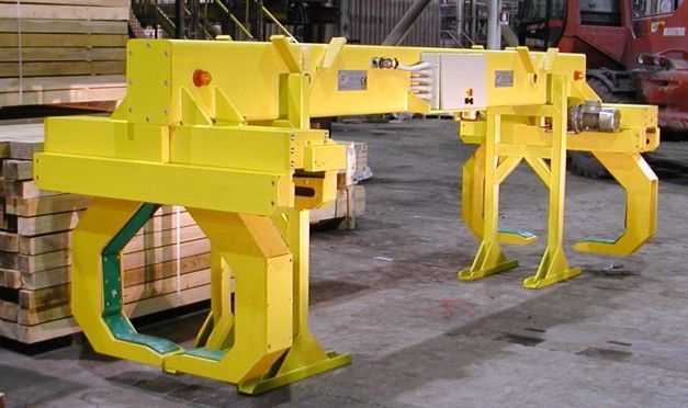 Pinza industriale gialla per il sollevamento e lo spostamento di materiali.