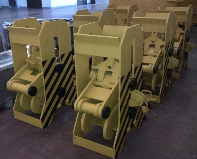 Attrezzature industriali gialle con strisce diagonali nere, allineate all'interno.