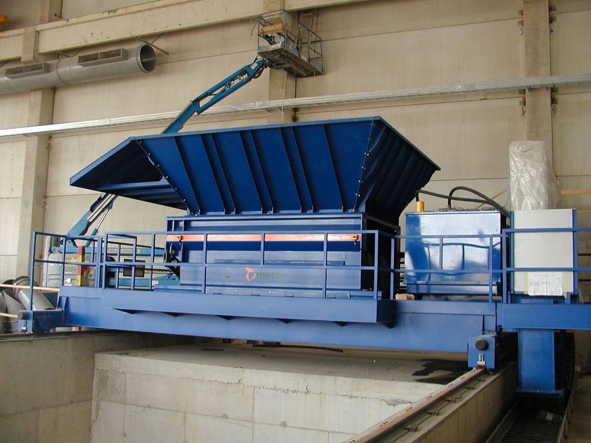 Macchina industriale blu all'interno di un grande edificio di colore chiaro.