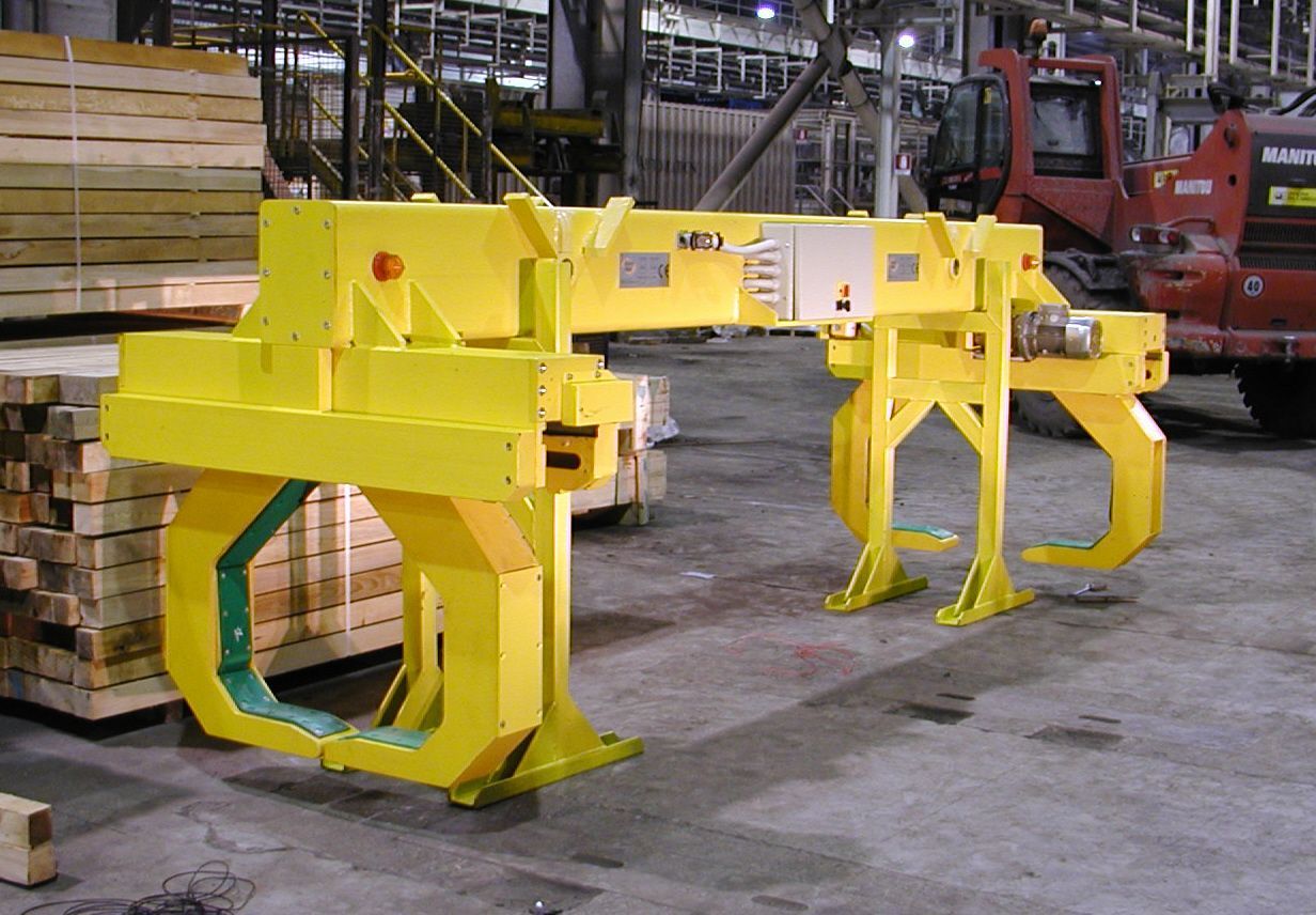 Dispositivo di sollevamento del legname industriale giallo in un magazzino.