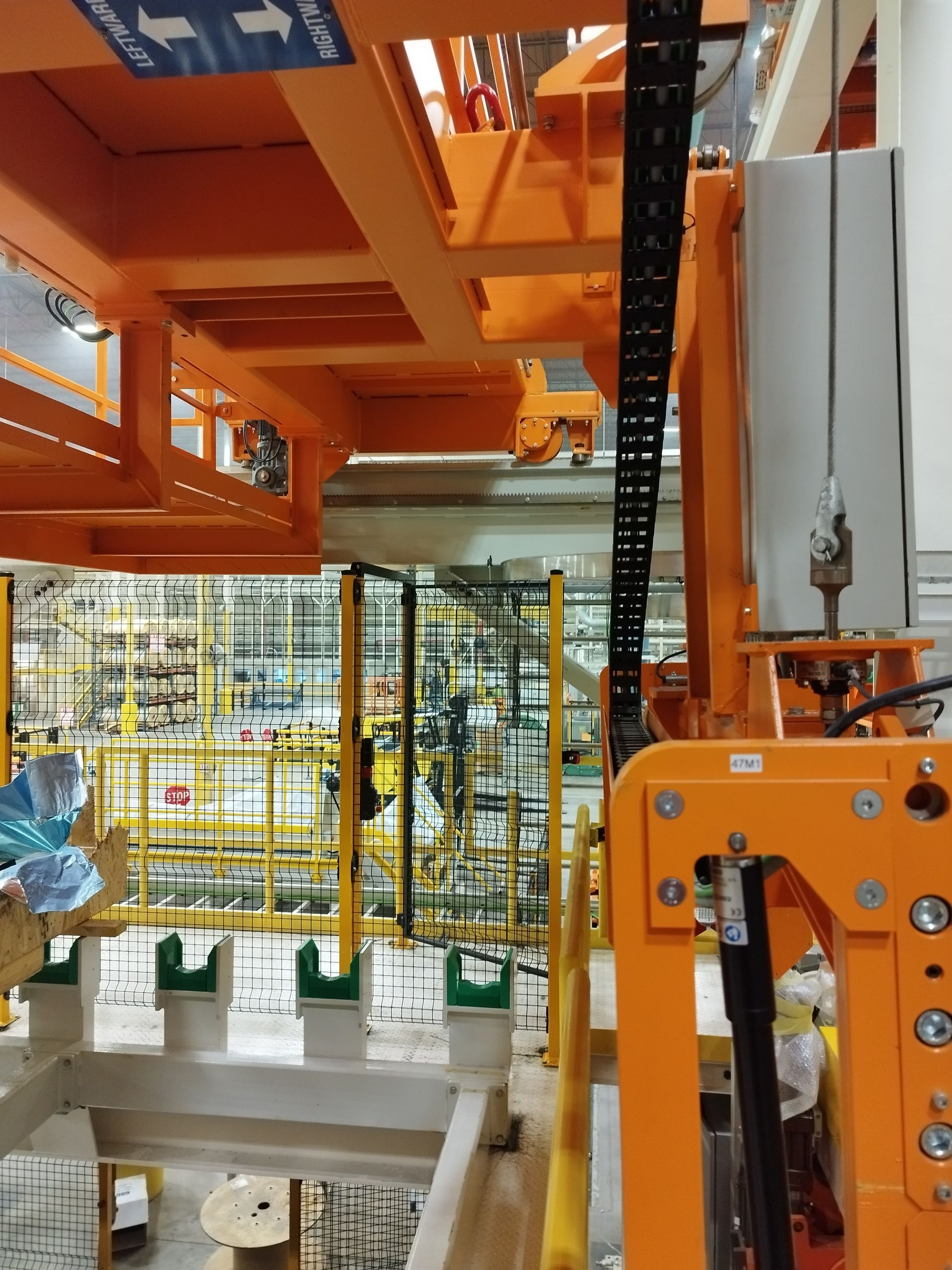 Macchinari industriali arancioni con cavi neri, in un ambiente di fabbrica.