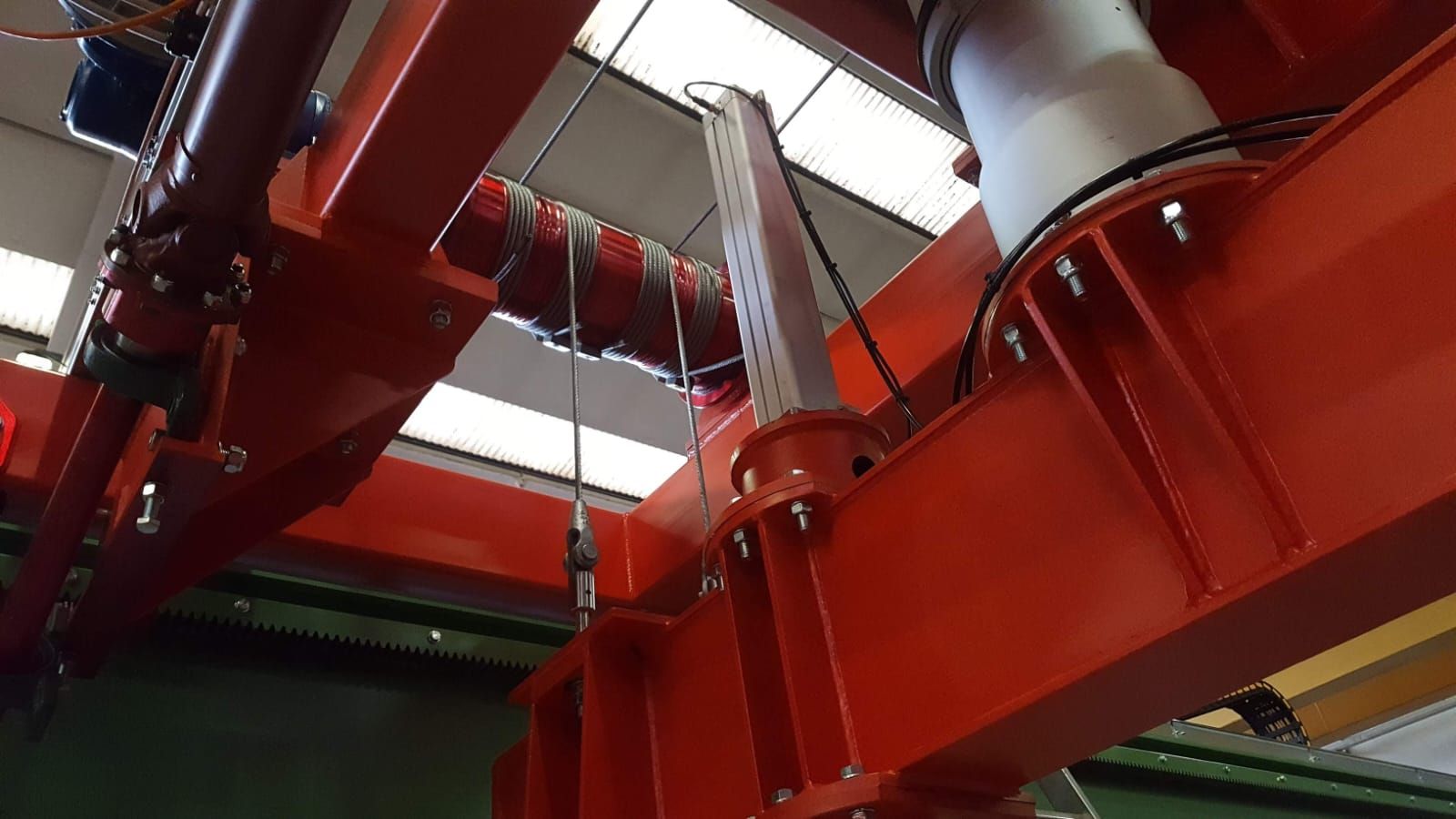 Gru a ponte rossa in un ambiente di fabbrica.