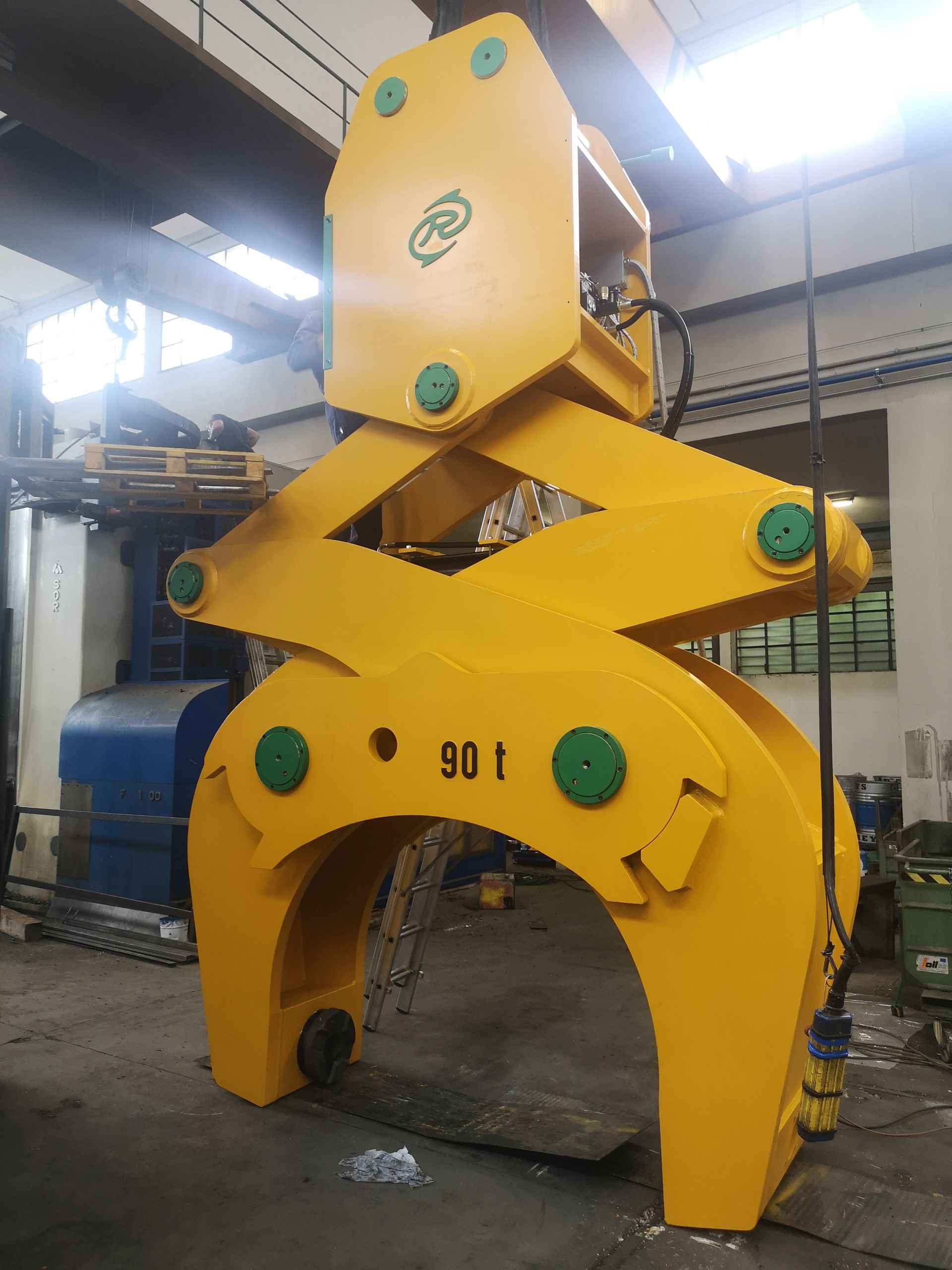 Pinza di sollevamento industriale gialla, etichettata 90 t, in configurazione di fabbrica.