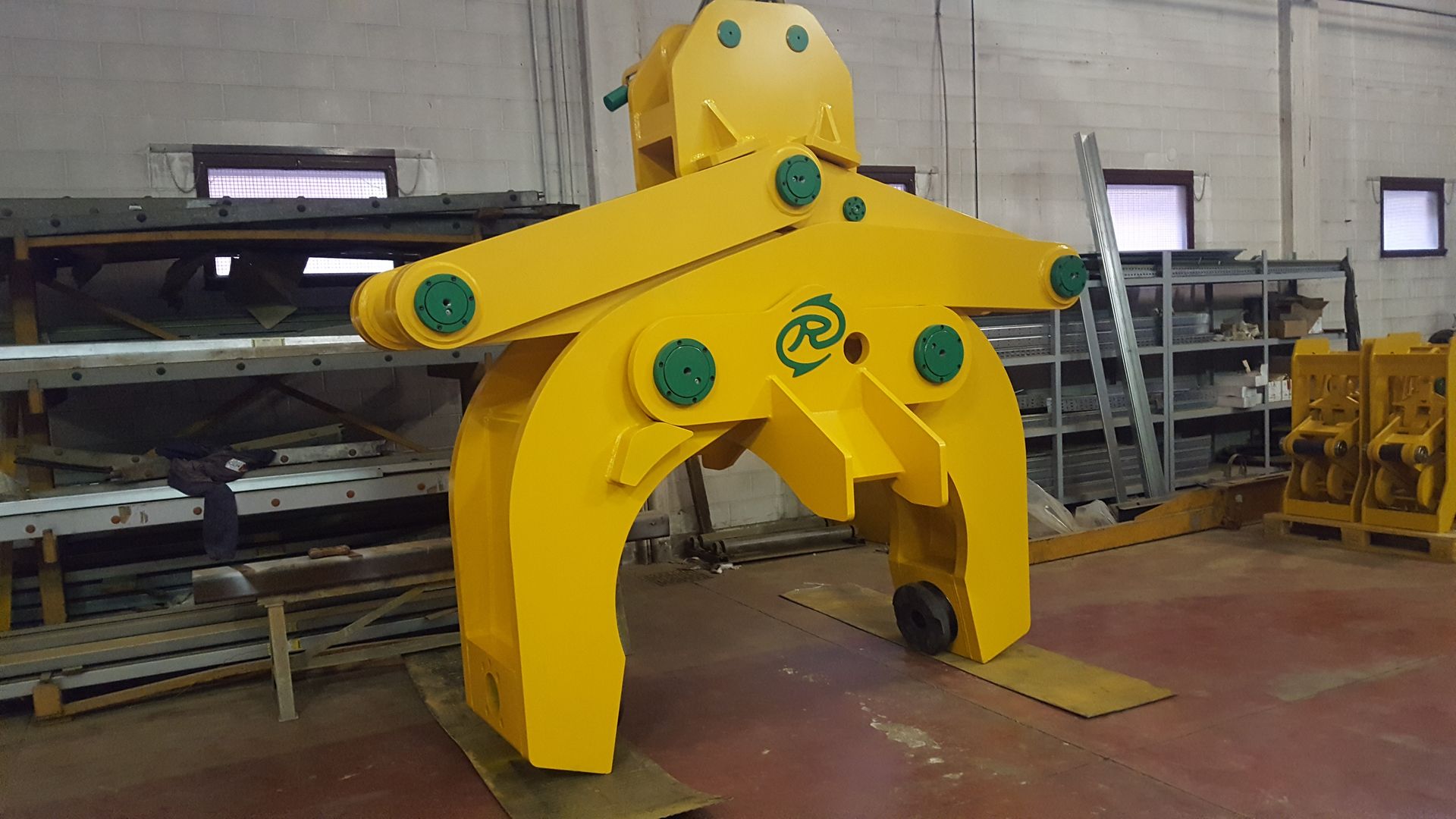 Pinza di sollevamento industriale gialla in un magazzino.