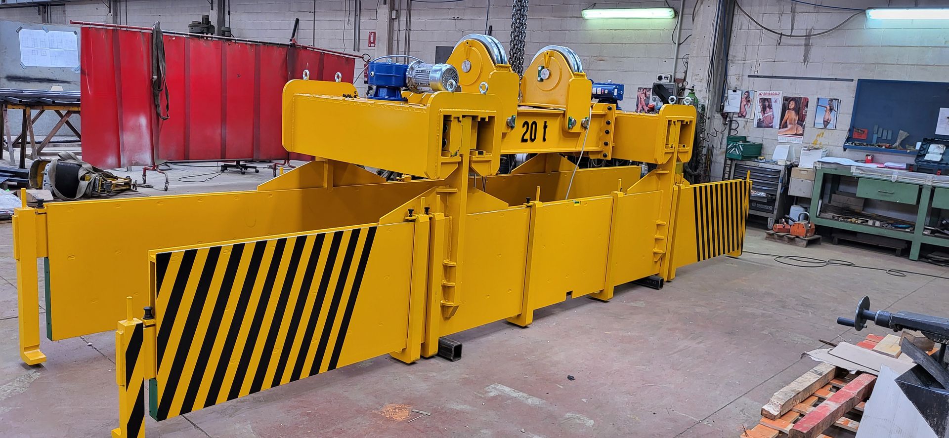 Macchina industriale gialla con dettagli a strisce nere in un'officina.