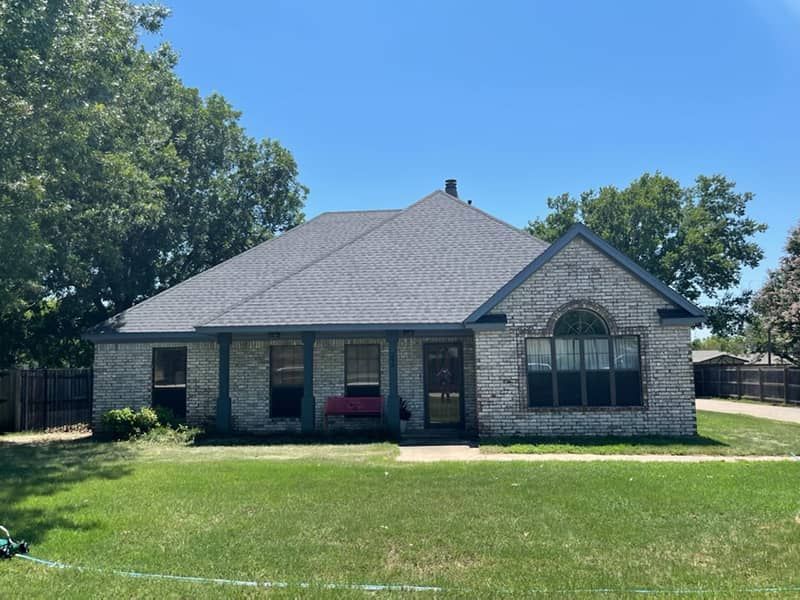 A white brick house with a gray roof