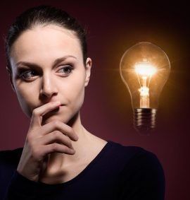 A woman is thinking with a light bulb in the background.