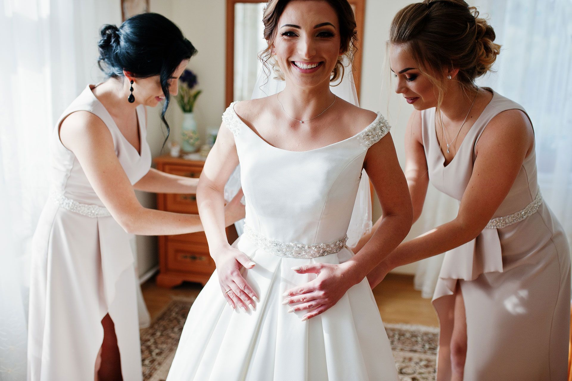 Bridesmaids helping gorgeous bride