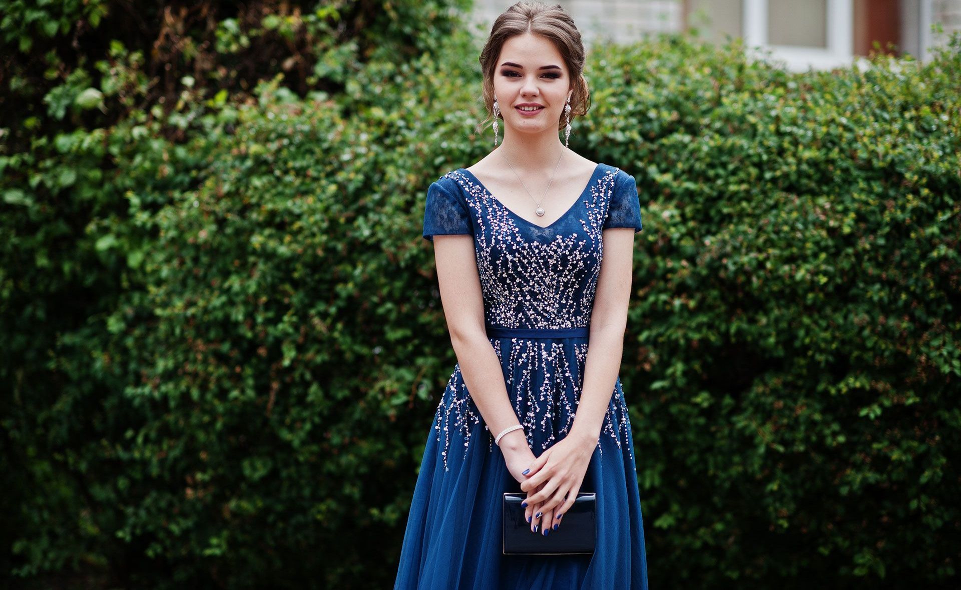 Portrait of a beautiful and gentle girl in elegant gown posing outdoo