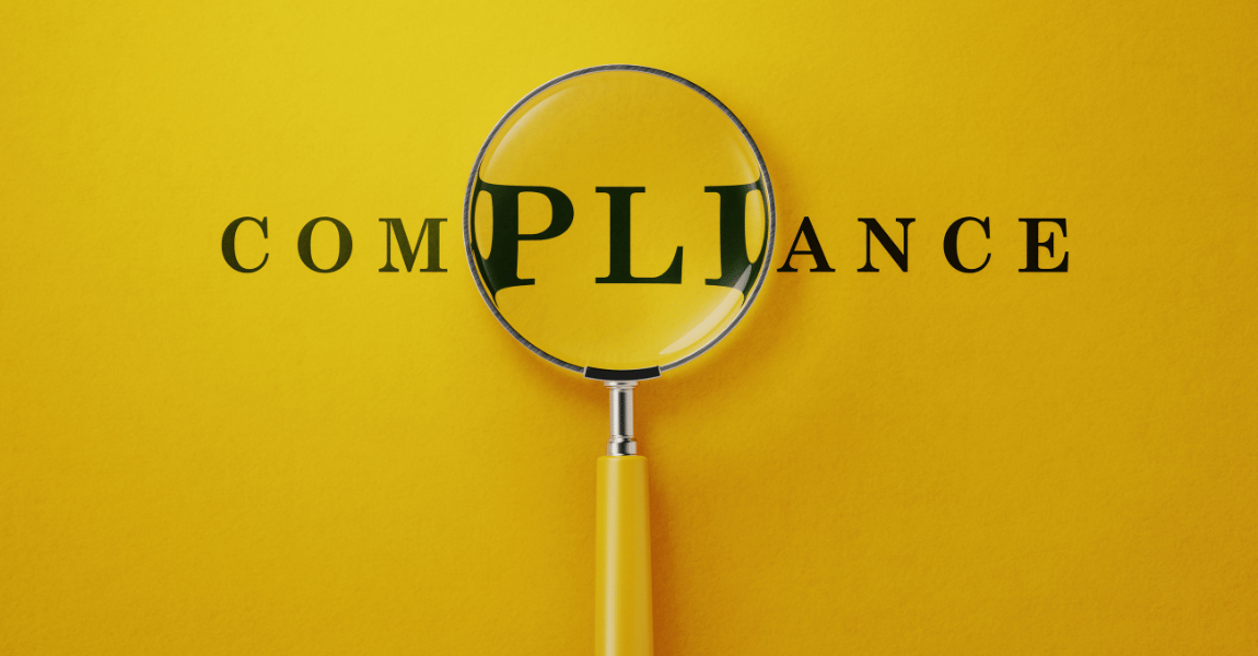 A magnifying glass is looking at the word compliance on a yellow background.