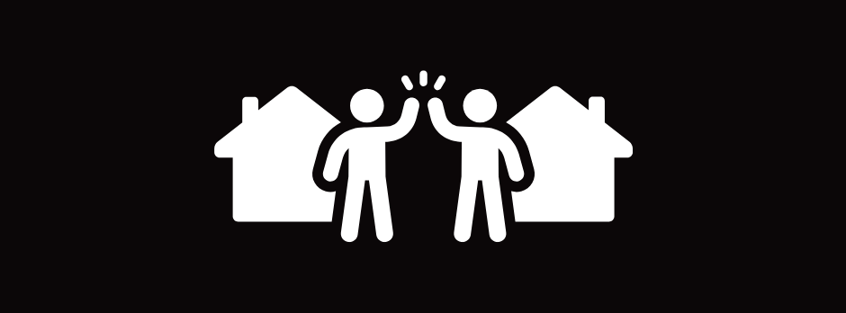 Two people are giving each other a high five in front of two houses.