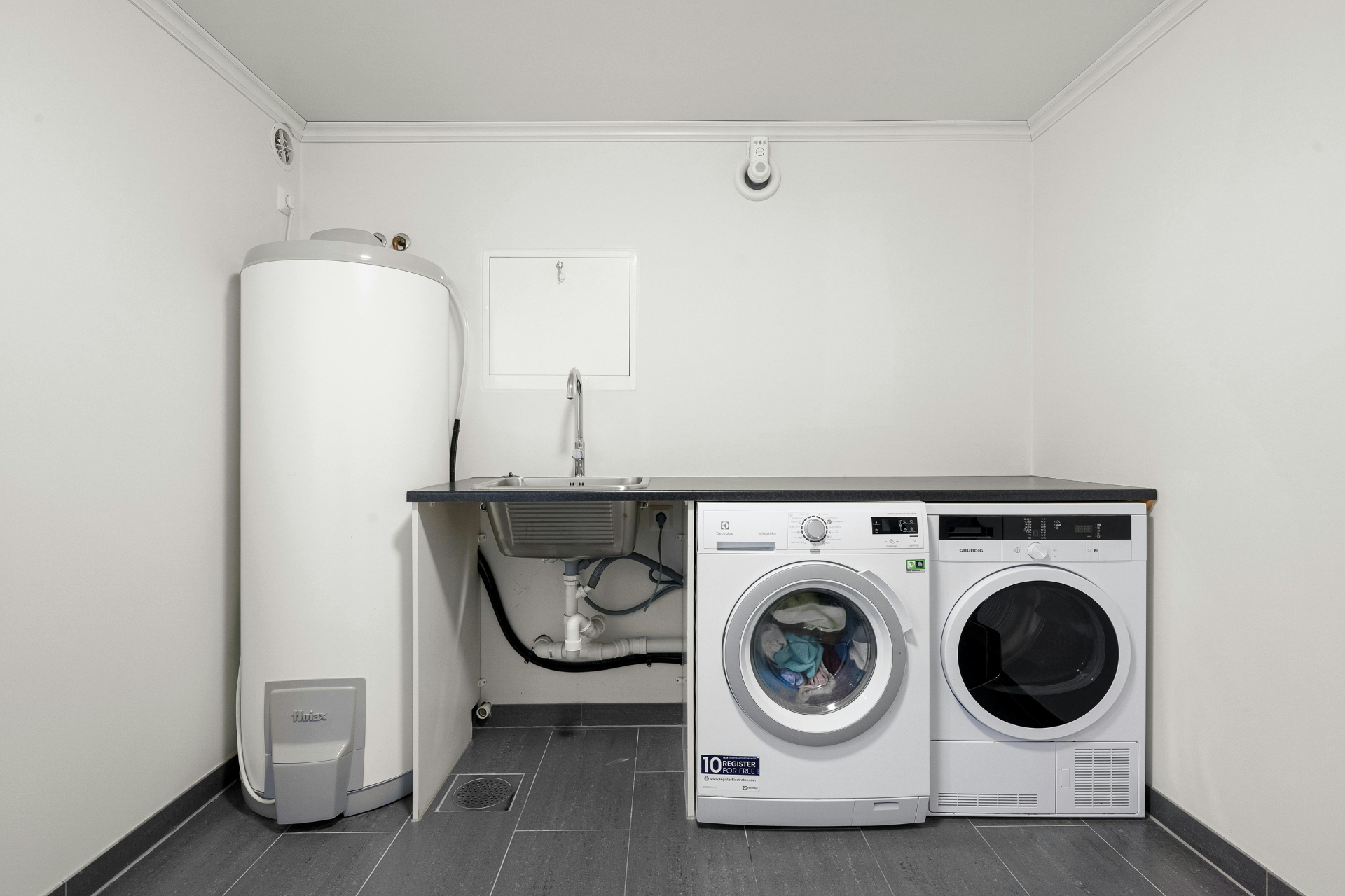 A laundry room with a washer and dryer and a water heater.