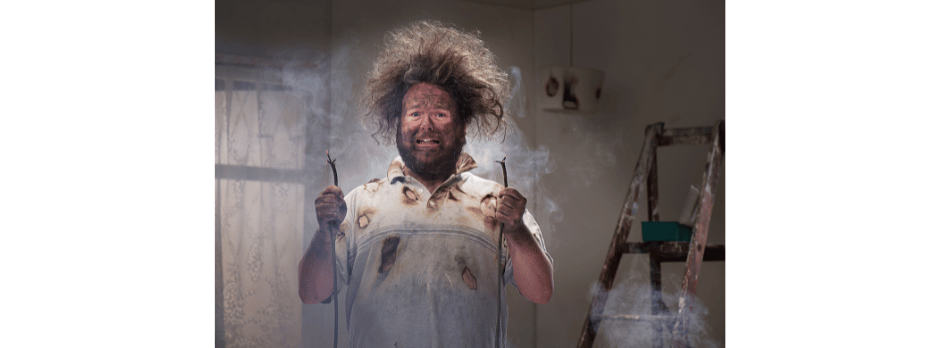 A man with a beard is standing in front of a glass door.