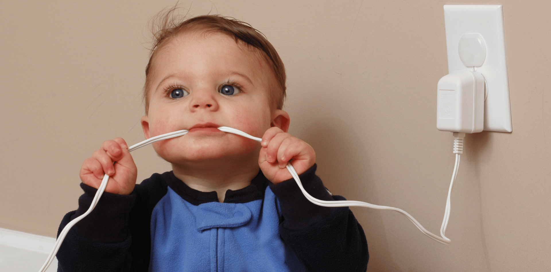 Cild chewing on an electrical cord