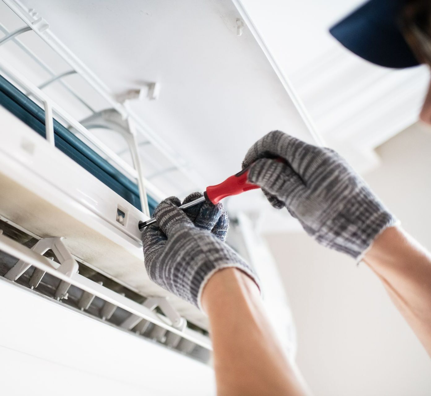 Technician repairing air conditioner with screwdriver working on the internal components of the AC. — Nashville, TN — Hermitage Heating & Air Conditioning