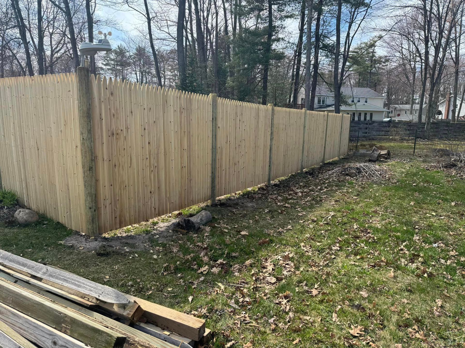 A wooden fence is sitting in the middle of a grassy field.