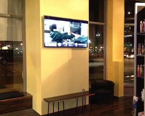 A flat screen tv is mounted on a wall in a room
