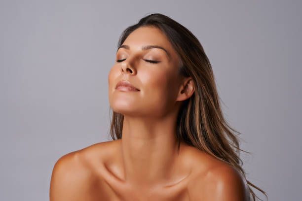 A close up of a woman 's face with her eyes closed.