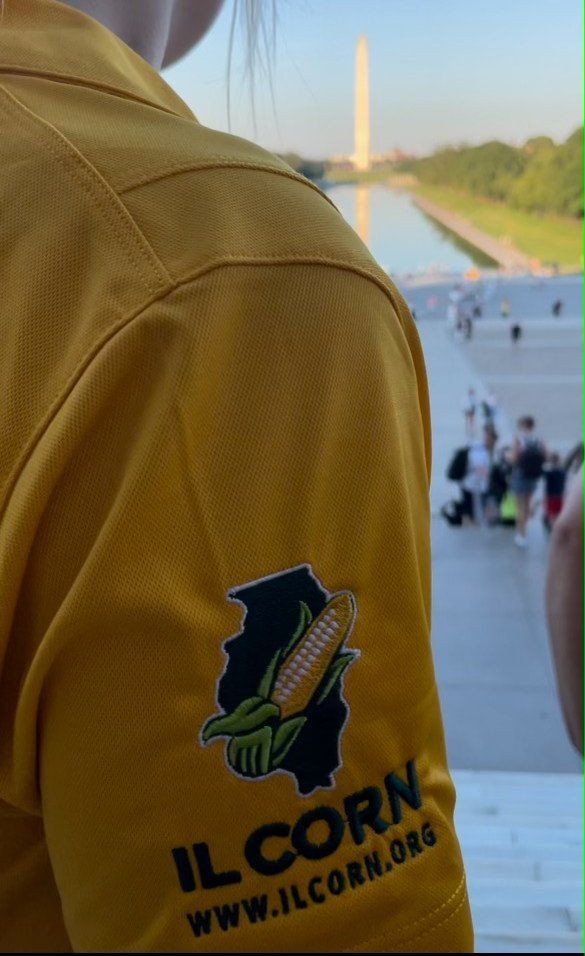 A person wearing a yellow shirt that says il corn