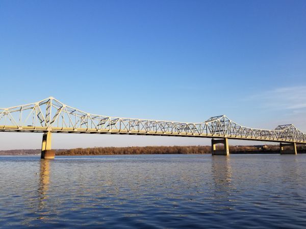 A bridge over a body of water with a blue sky in the background.