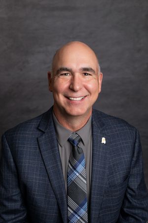 A man in a suit and tie is smiling for the camera.