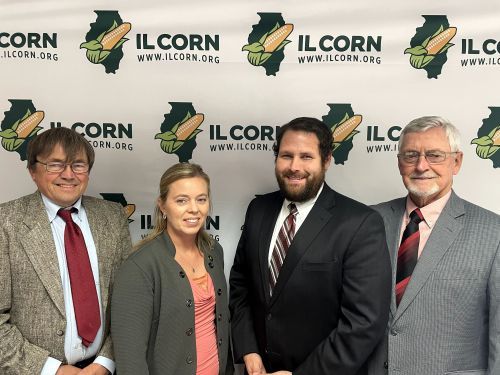 A group of people standing in front of a banner that says ilcorn